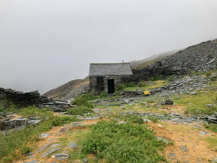 Eine alleinstehende Berghütte aus grauem Stein