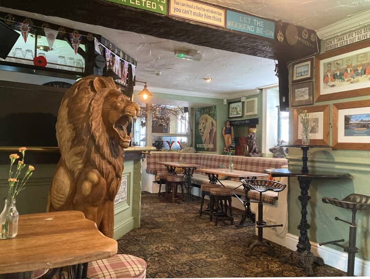 Der Innenraum eines Pubs mit einer fast lebensgroße Holzfigur in Form eines Löwen mit geöffnetem Maul